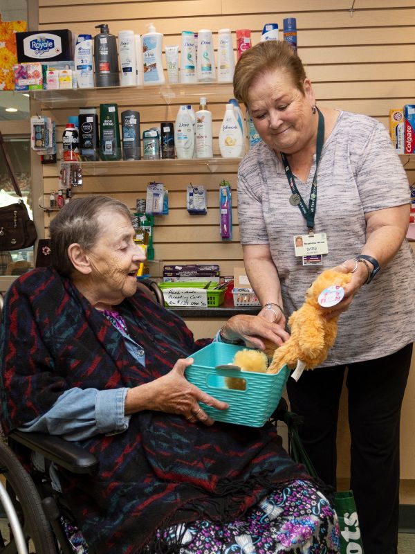 Dearness volunteer at Tuck Shop with resident.